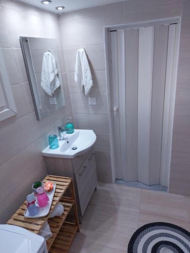 a bathroom with a sink and a mirror and a shower at Afandou Square Apartment in Afantou