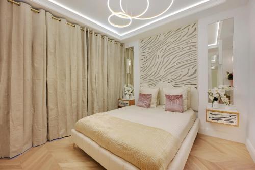 une chambre avec un lit et un lustre dans l'établissement Bretagne Mairie du 3e, à Paris