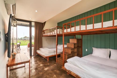 een slaapkamer met 2 stapelbedden en een tafel bij Champ Villa Long An in Ấp Bình Yên