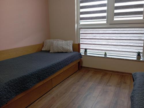 a bedroom with a bed and a window at Cozy New Apt - Уютен апартамент in Blagoevgrad