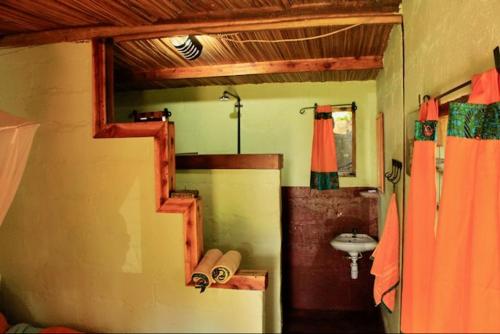 a room with a bathroom with a sink and a mirror at Explorers River Camp in Jinja