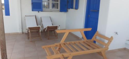 una stanza con sedie, tavolo e panca di Hotel Posidonion a Koufonisia