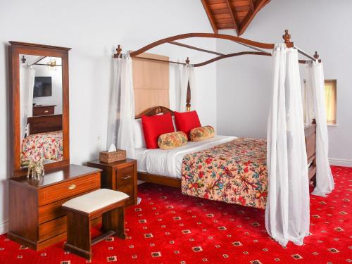 um quarto com uma cama de dossel e um tapete vermelho em Little England by Joes em Nuwara Eliya