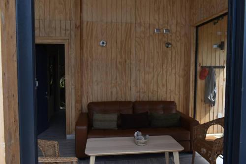 a living room with a brown couch and a table at Impressive Don Santiago Cabin, Chilean Patagonia. in Chaitén