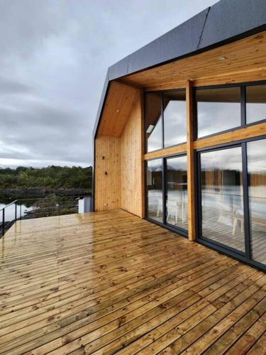 a wooden deck with windows on a house at Impressive Don Santiago Cabin, Chilean Patagonia. in Chaitén