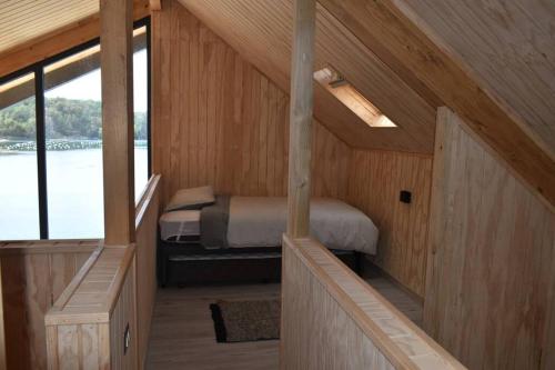 a small room with a bed in a wooden house at Impressive Don Santiago Cabin, Chilean Patagonia. in Chaitén