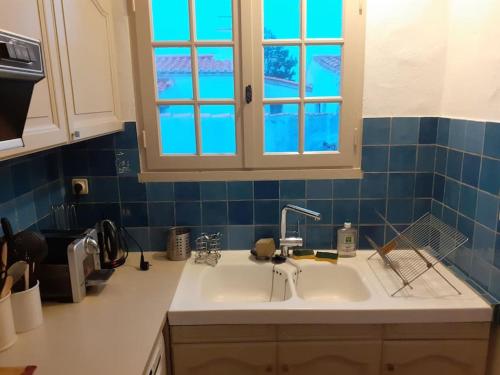 un comptoir de cuisine avec un évier et une fenêtre dans l'établissement Belle maison familiale à 3 minutes de la plage, à LʼÉpine