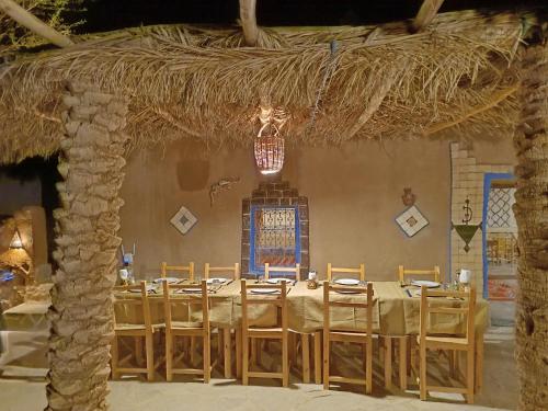 une salle à manger avec une grande table et des chaises dans l'établissement kasbah hotel Luna, à Erfoud