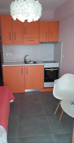 a kitchen with orange cabinets and a sink and a microwave at Ormos View Apartments in Ormos Panagias