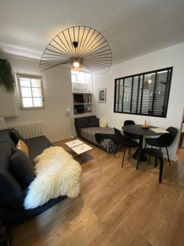 uma sala de estar com um sofá e uma mesa em Le Cosy Intra - Appt Cocon Parking privé em Saint Malo
