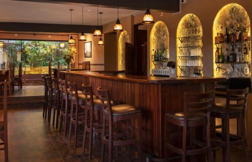 un bar con taburetes de madera en un restaurante en La Vida es Bella, en Samaipata