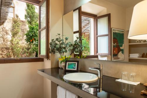 uma casa de banho com um lavatório e um espelho em SólleRooms em Sóller