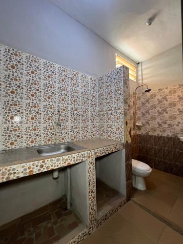 y baño con lavabo y aseo. en DG Hôtel en Cotonú