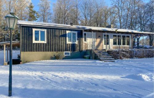 a small house in the snow with a street light at Lovely Home In Ormaryd With Sauna in Ormaryd