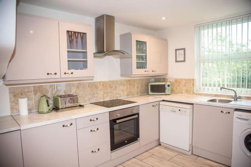 a kitchen with white cabinets and a sink at Cosy and Spacious House for 6 in Rochester