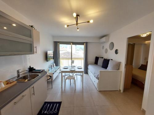 une cuisine et un salon avec un canapé et une table dans l'établissement T2 au calme, proche des plages, climatisé et parking privé, à Cagnes-sur-Mer
