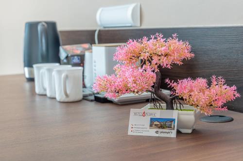 a table with flowers in vases on a desk at Motel "Płomyk" in Kunowice