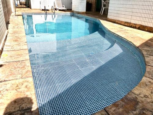 a swimming pool with a black and white grid around it at Flat Ponta Negra vista para o mar in Natal