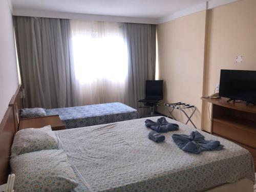 a hotel room with two beds and a television at Flat Ponta Negra vista para o mar in Natal