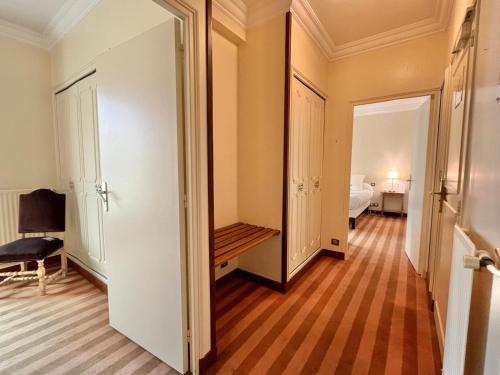 a hallway with a door to a room with a bed at Logis Hôtel Le Rivage in Gien