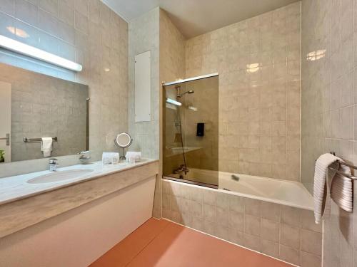 a bathroom with a tub and a sink and a shower at Logis Hôtel Le Rivage in Gien