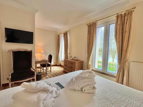 a bedroom with a bed with towels on it at Logis Hôtel Le Rivage in Gien