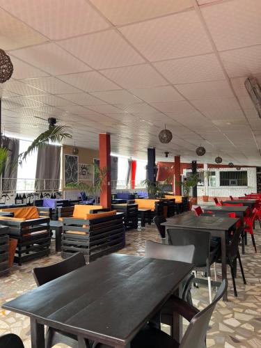 una sala da pranzo con tavoli e sedie in un ristorante di DG Hôtel a Cotonou