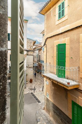 an alley with a green door on a building at SólleRooms in Sóller