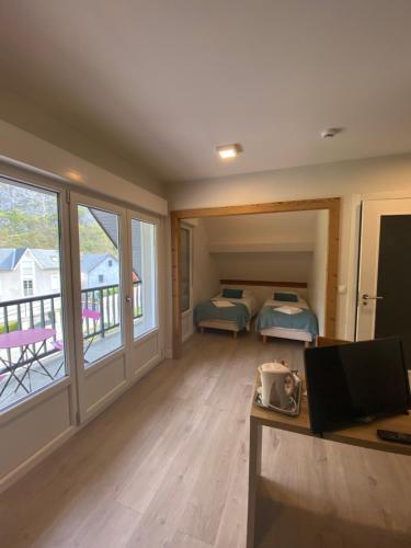 a room with a desk and a bedroom with a balcony at Hotel Le Chalet in Sainte-Marie-de-Campan