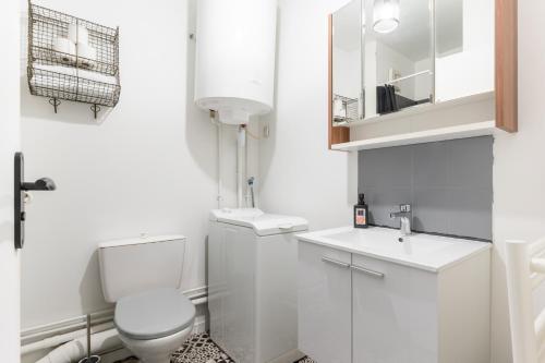 une salle de bain blanche avec des toilettes et un lavabo dans l'établissement Studio Centre-Ville avec Terrasse et Parking Sécurisé Gratuit, à Nantes