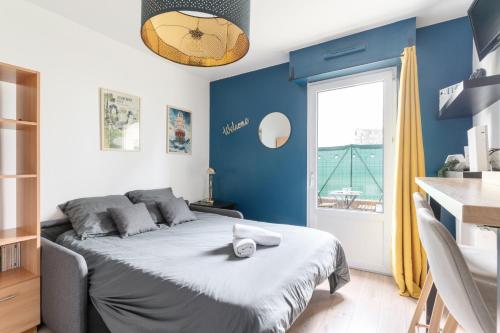 une chambre avec un lit aux murs bleus et une fenêtre dans l'établissement Studio Centre-Ville avec Terrasse et Parking Sécurisé Gratuit, à Nantes