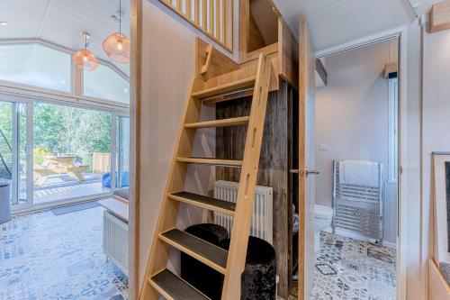 a room with a wooden staircase in a house at Hillside Cabin in Caersws
