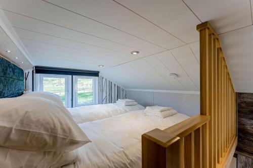 a bedroom with two beds and a large window at Hillside Cabin in Caersws