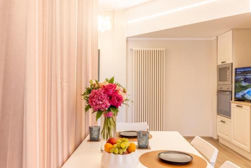 a table with a vase of flowers and fruit on it at TENUTA FOGLIANI Resort & Natural Spa in Visciano