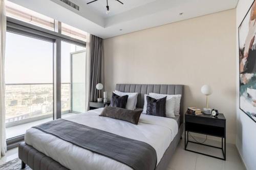 a bedroom with a large bed and a large window at Chic One Bedroom Apartment with Full Sea View in Dubai