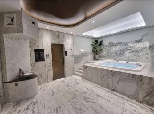 a large bathroom with a tub and a sink at Chic One Bedroom Apartment with Full Sea View in Dubai