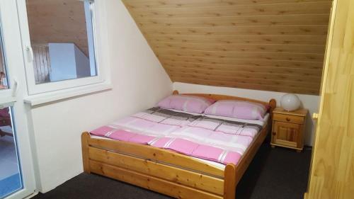 a small bed in a room with a window at Chata Marta in Liptovské Kľačany