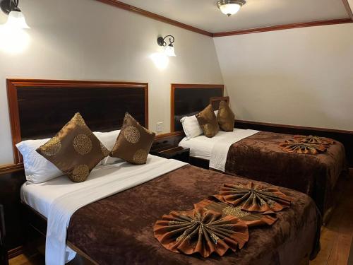 a hotel room with two beds with pillows on them at Captain Morgan's Retreat in San Pedro