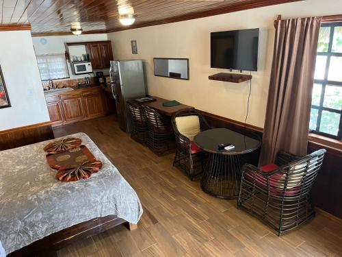 a room with a bed and a kitchen with a tv at Captain Morgan's Retreat in San Pedro