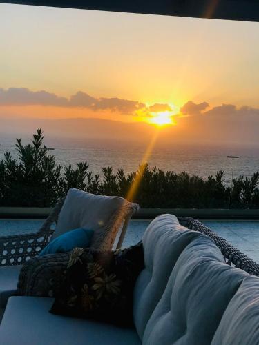 a person laying in a wicker chair in front of a sunset at Mavi Panorama Villa in Cesme