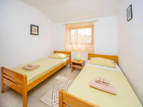 a bedroom with two beds and a window at Apartment Jadria near the beach in Šibenik