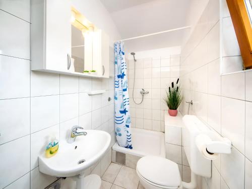 a white bathroom with a toilet and a sink at Apartment Jadria near the beach in Šibenik