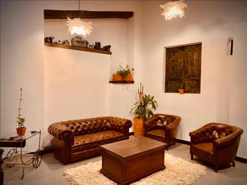 Hotel Quinta Bolivar في بوغوتا: غرفة معيشة مع كنب جلدي وطاولة