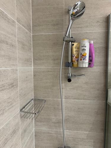 a shower with a shower head in a bathroom at Beautiful Cozy Studio (Masdar City) in Al Qurayyah