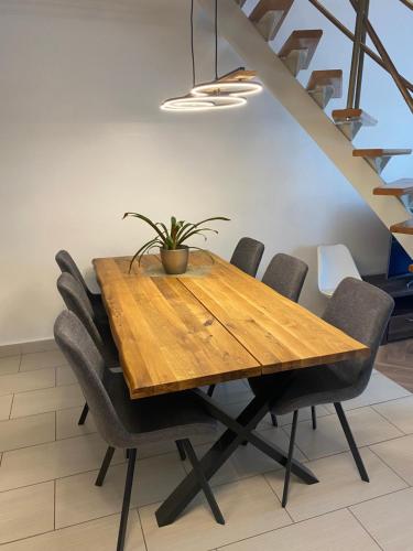 a wooden table with chairs and a potted plant on it at Erelia Cottage in Bük