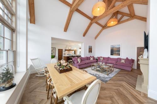 a living room with a wooden table and purple furniture at Luxury in the Lake District in Dockray