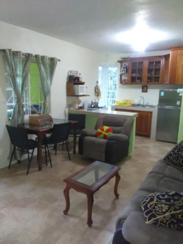 Una sala de estar con un sofá y una mesa y una cocina. en Mountain View, Jacks Hill, en Kingston