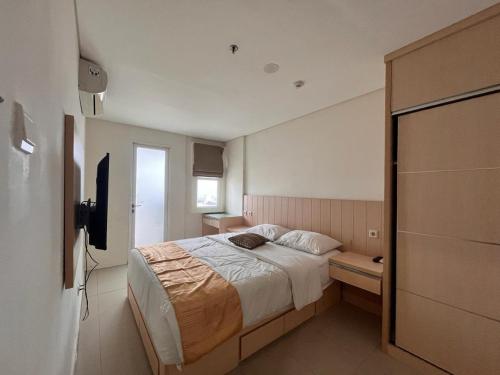 ein Schlafzimmer mit einem großen Bett und einem TV in der Unterkunft Comfy Rooms at Parahyangan in Bandung