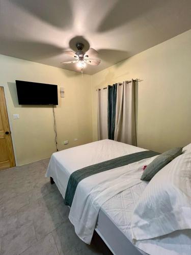 a bedroom with a bed and a ceiling fan at Sea-Renity Hideaway (Studio Apt) in Woods