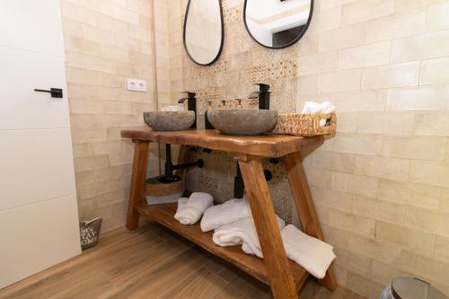 Baño con 2 lavabos en una estantería de madera en Apartamentos La Escapada, en Alhama de Aragón